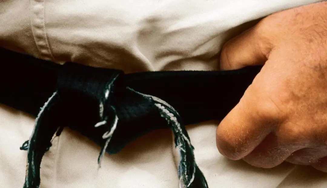 A black belt tied around a white karate gi
